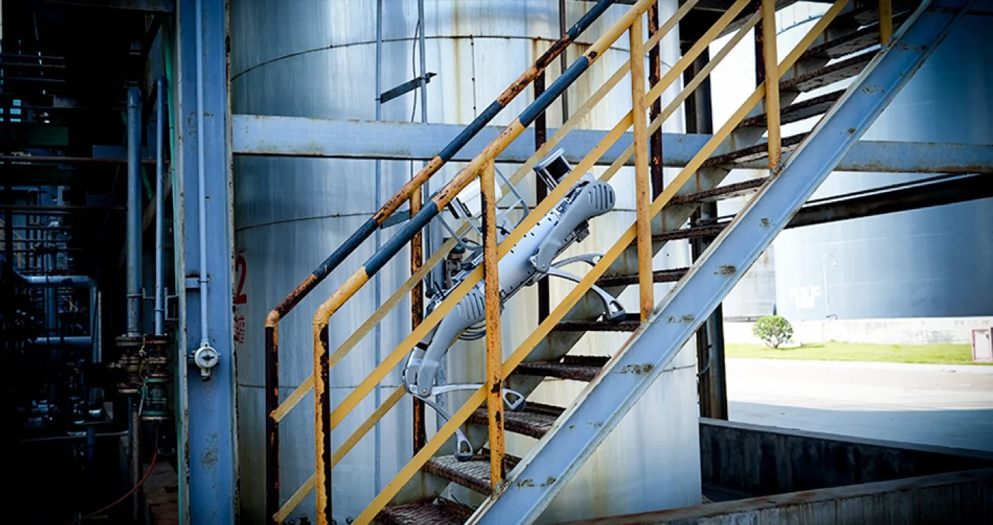 Unitree B2 climbing an industrial staircase at a tank farm