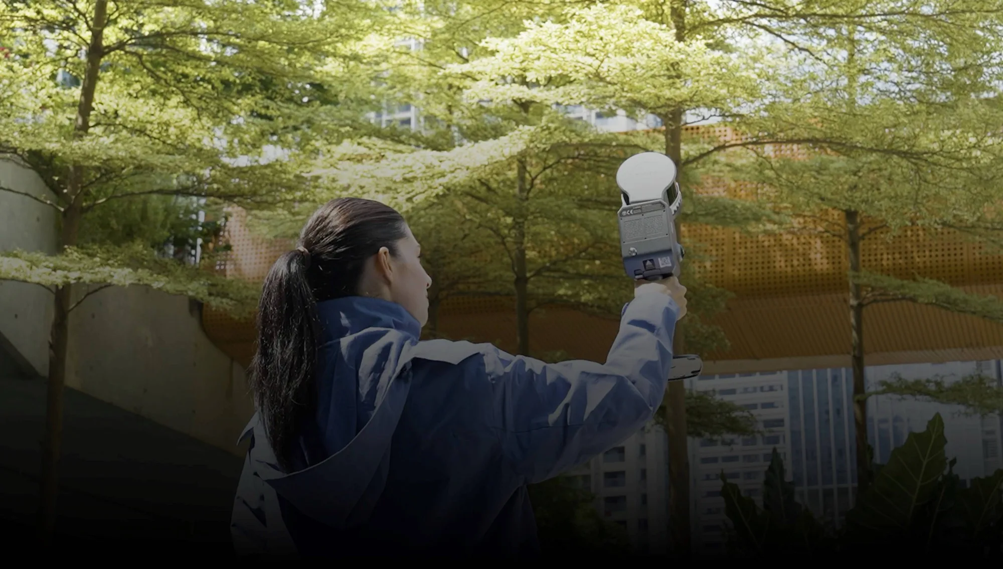 Operator using an XGRIDS Lixel L2 Pro handheld LiDAR scanner outdoors