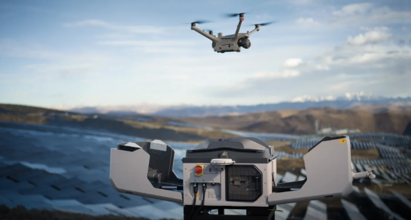 Drone launching from a DJI Dock 3 with a solar farm in the background